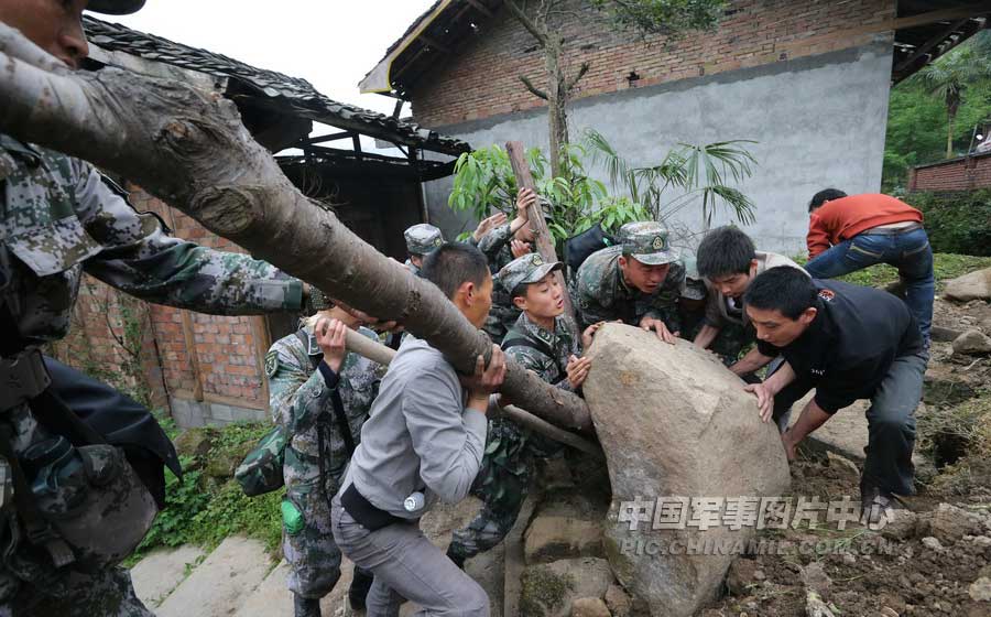 4月21日上午，记者在芦山地震中心灾区太平镇，摄下了13军某炮兵团官兵在帮助村民清理路障的情景。