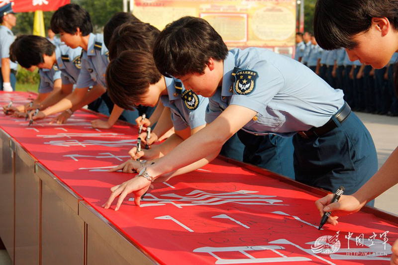 十八大召开当天,这16名女学员更是独立策划组织了学习贯彻十八大精神演讲比赛。在不到一个半小时的比赛中,选手们精彩的演讲,透射着新一代歼击机女飞行员对党的无限忠诚,对祖国的无比热爱,对事业的崇高追求。图为入旅仪式签名(董亚新 摄)